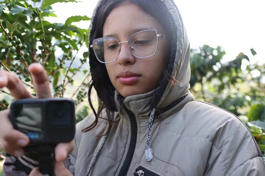 Joven explorando la grabación audiovisual en un cafetal