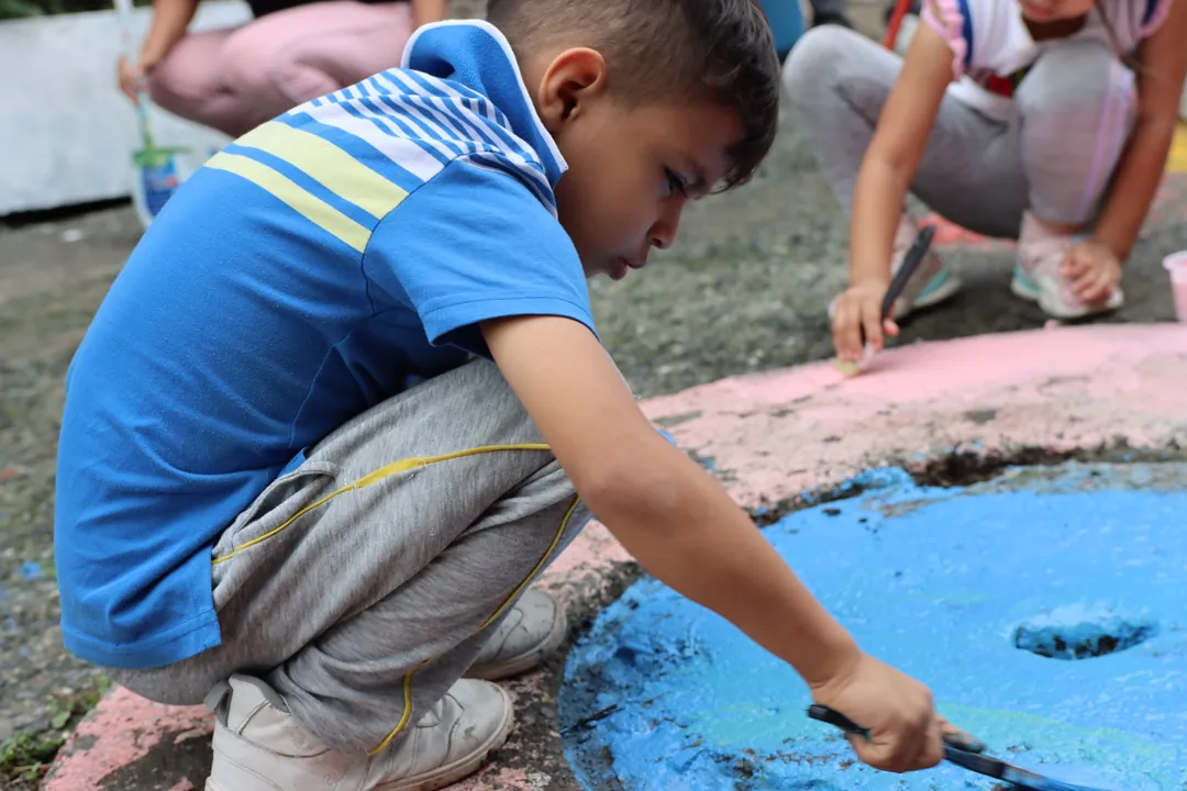 Niño pintando durante una actividad comunitaria